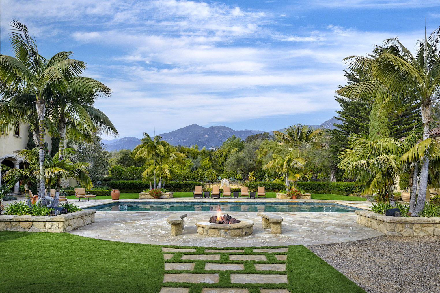 The backyard of a luxury estate with pool and amazing mountain view behind.