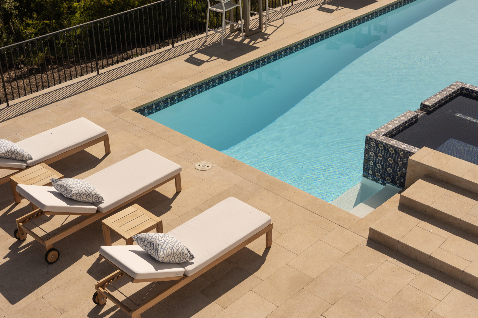 Resort-style pool and spa at a luxury Montecito estate featuring sun loungers, elegant tilework, and expansive outdoor living spaces.