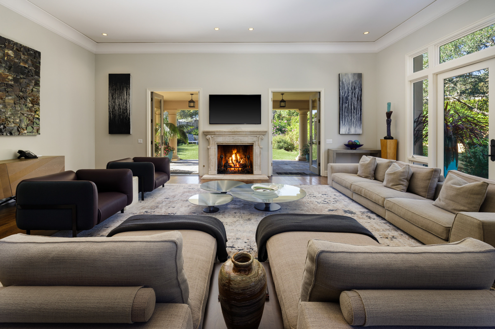 The great room of a Montecito luxury home with a fireplace and comfy furniture.