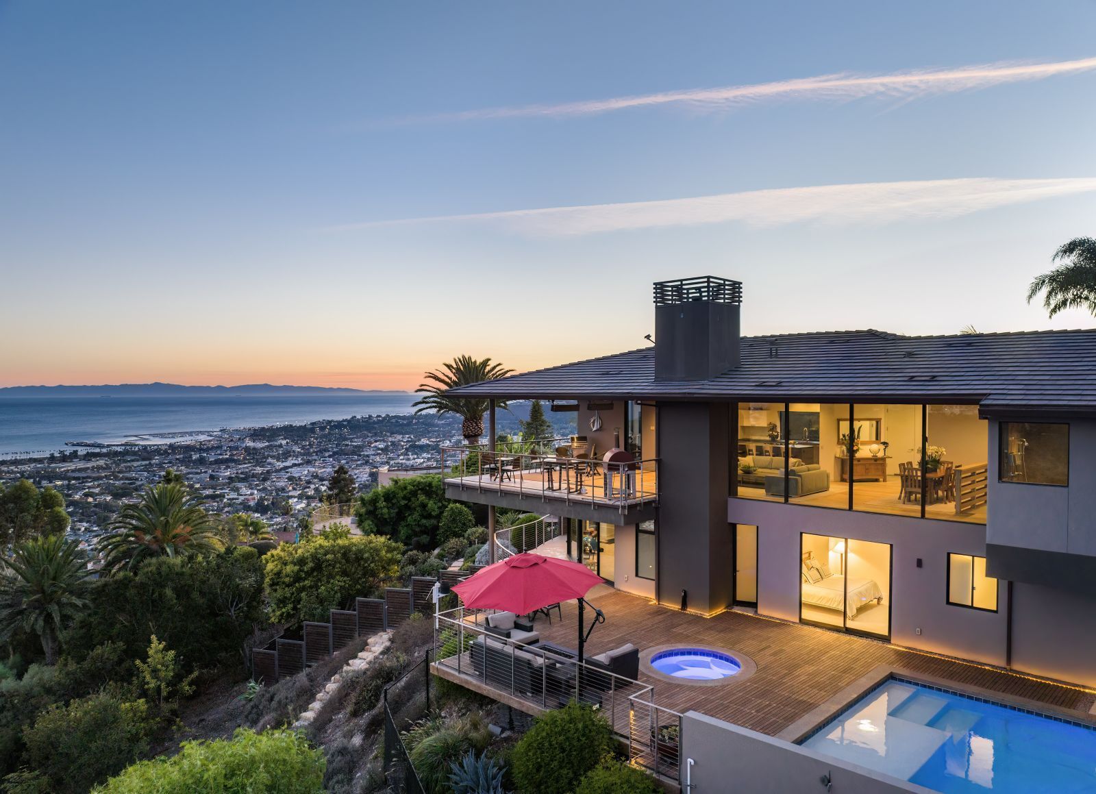 A contemporary Santa Barbara home illuminated within and looking out over the city and the ocean