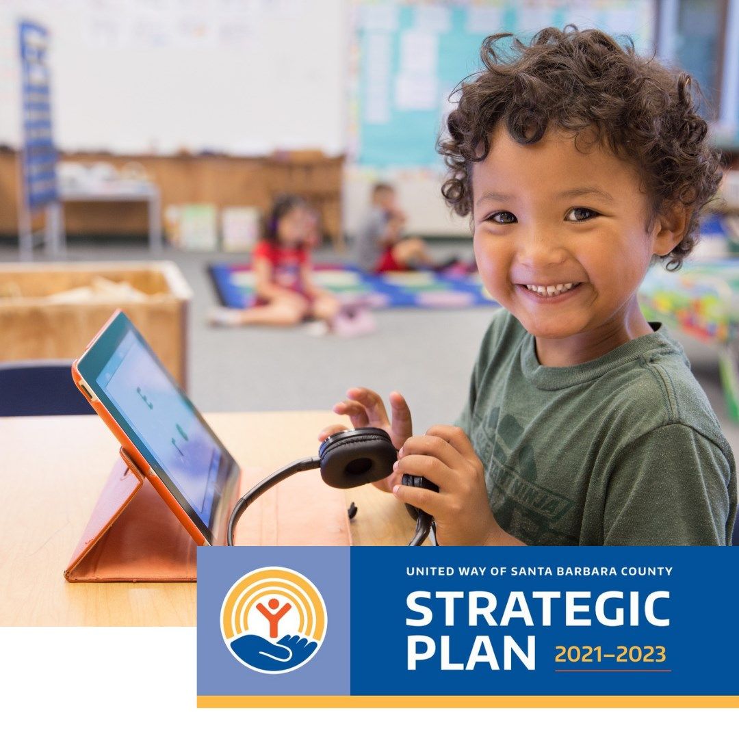 Smiling child in a school room working on a computer with other kids in the background and the words Strategic Plan at the bottom