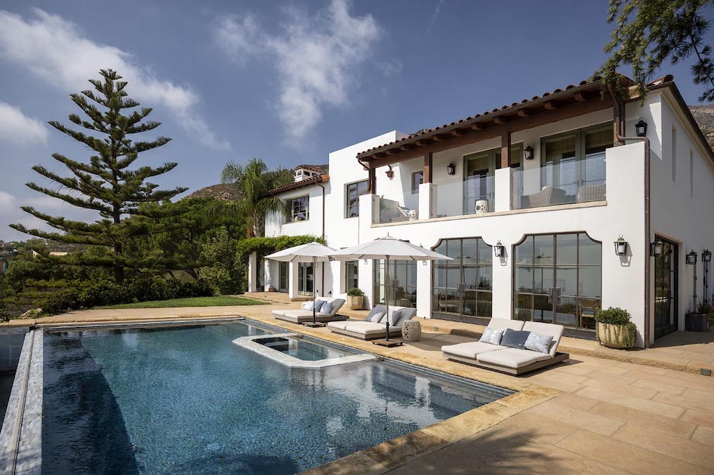 The backyard of a luxury Monteico hime complete with sparkling swimming pool and lounge chairs.