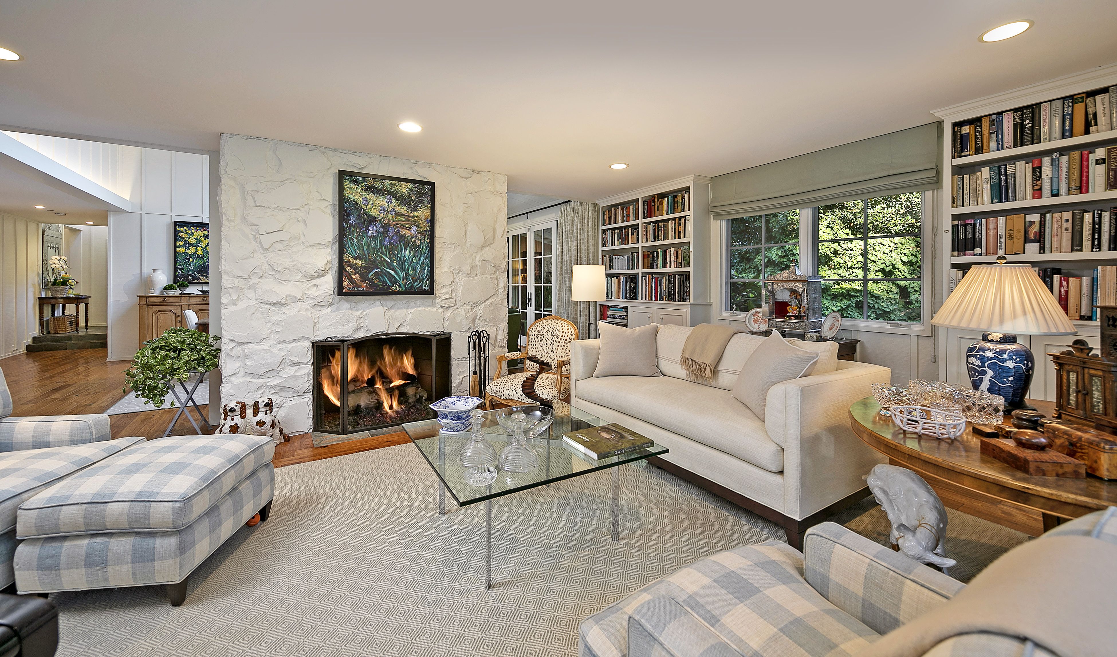 Casually sophisticated living rooms in a modern Santa Barbara farmhouse, with comfortable furniture andfire in the  fireplace
