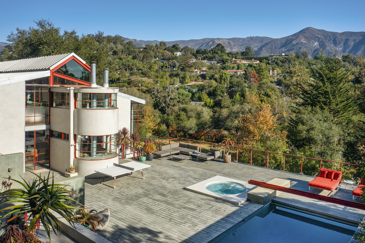 The backyard of a Mondernist home surrounded by the Snata Ynez Mountains with a sparkly pool in the foreground.