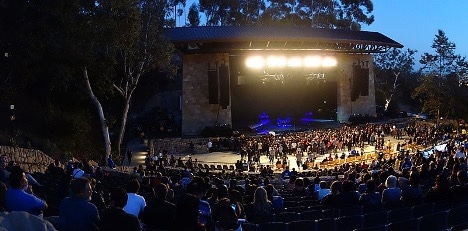 Evening concert at the outdoor Santa Barbara Bowl showing a lighted stage, with the audience in the foreground