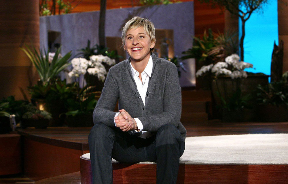 Ellen Degeneres sits on her show's stage smiling at the audience