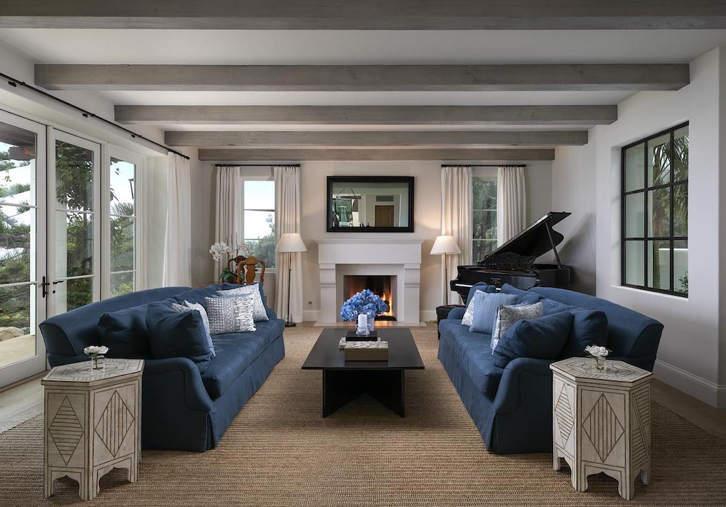 Living room of beautiful Montecito home with blue couches and a baby grande piano