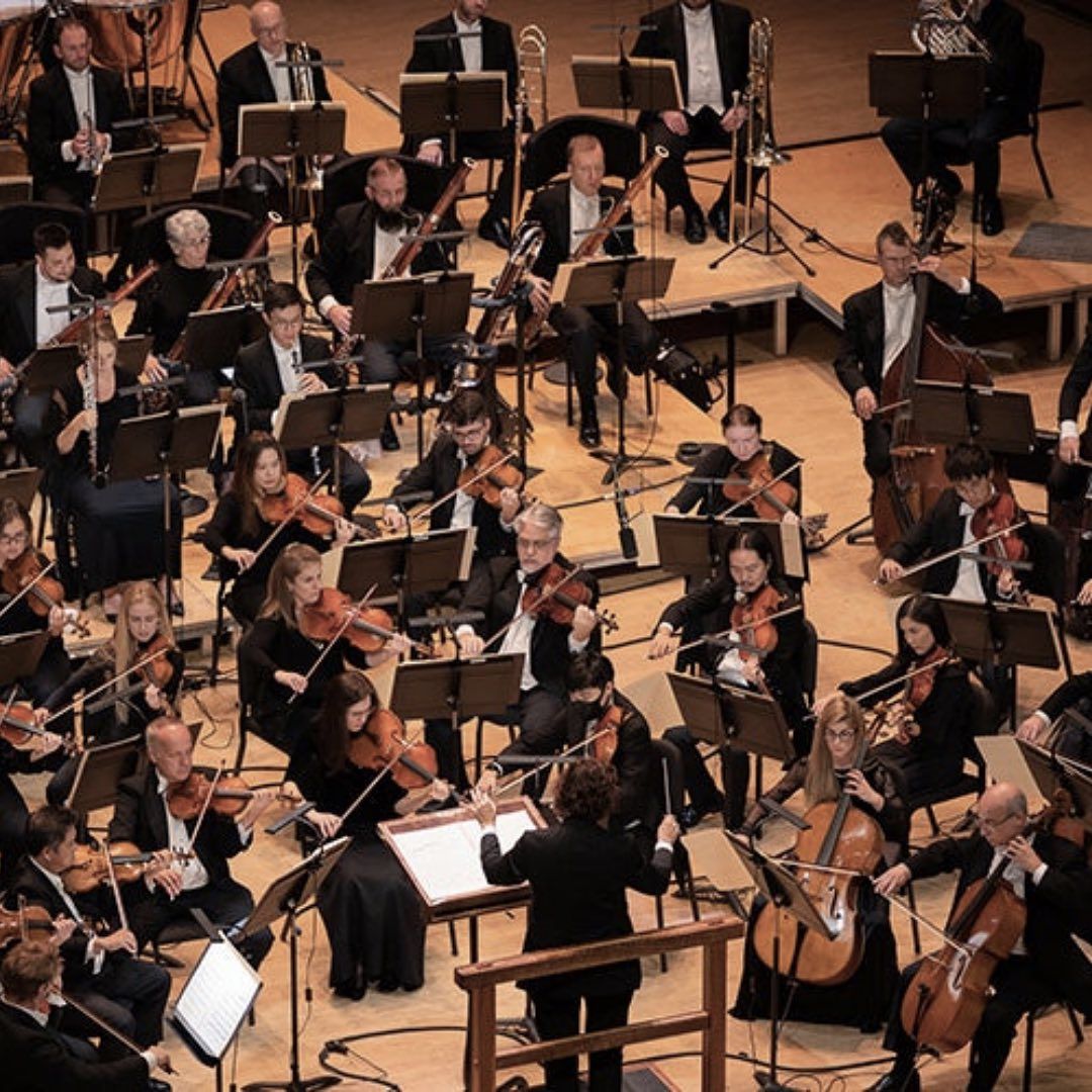 A birds eye view of an orchestra with members in tuxedos.