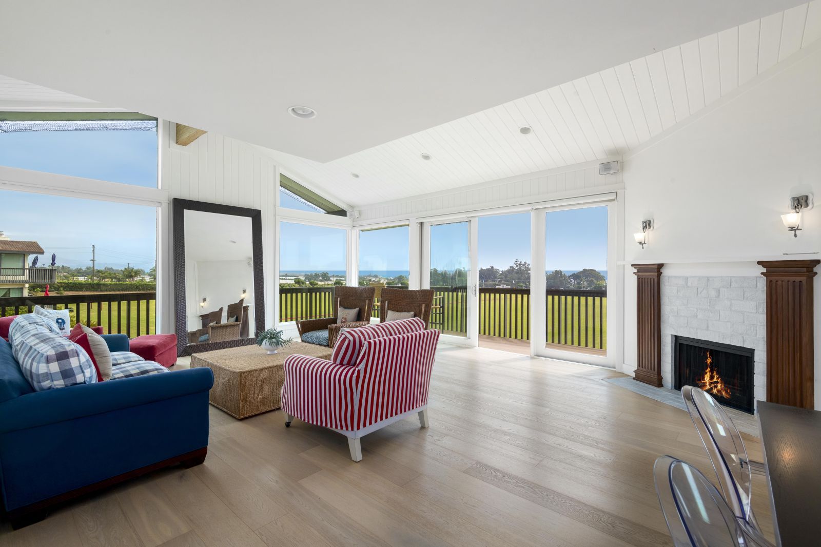 The spacious living room of a Santa Barbara Polo Club condo, with fireplace and ocean view