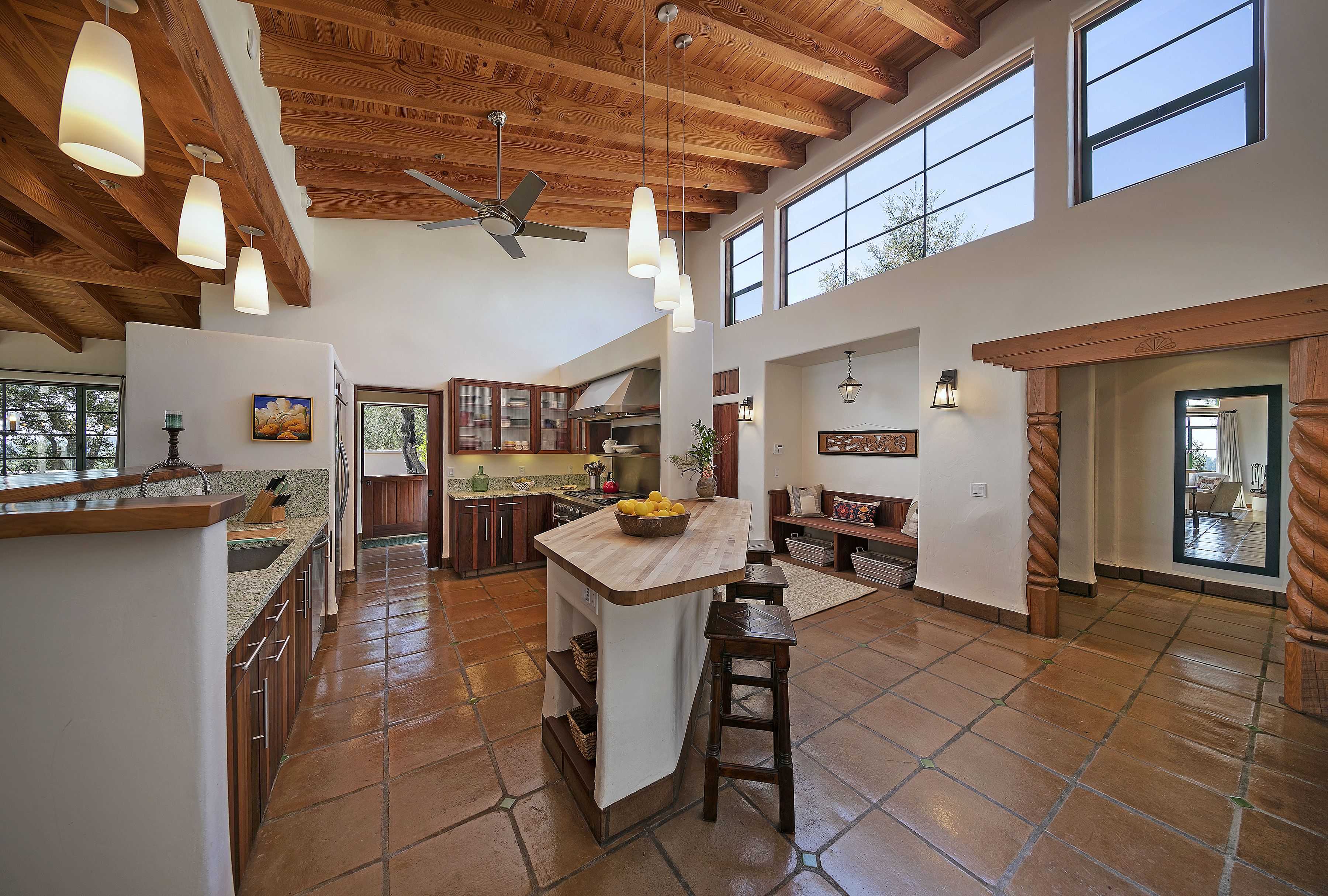 Luxurious kitchen with Saltillo-tiled floor, a beamed ceiling, and clerestory windows