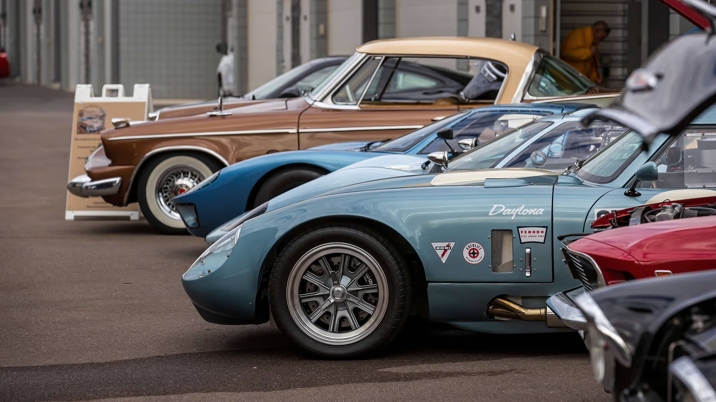 Some collectible cars outside a storage facitity.