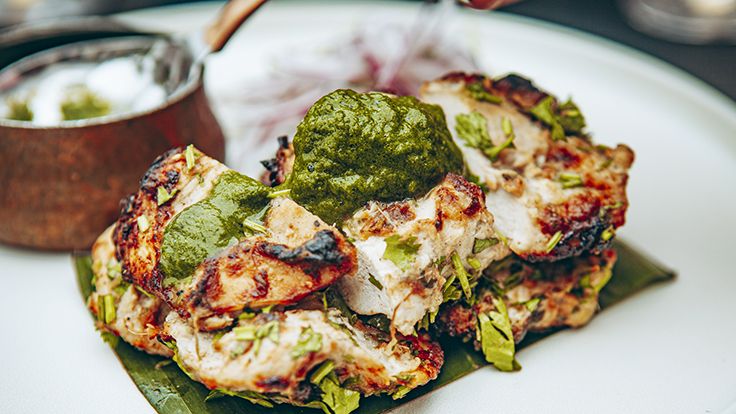 A delicious looking Indian chicken dish with cheese and green chutney