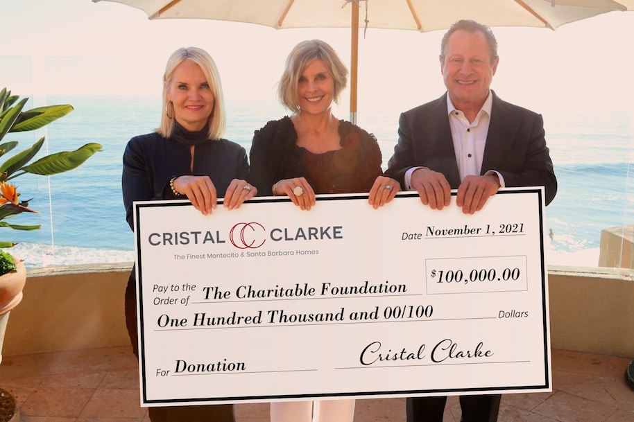 Realtor Cristal Clarke with giant check in theamount of $100,000 which she is donating to local charities