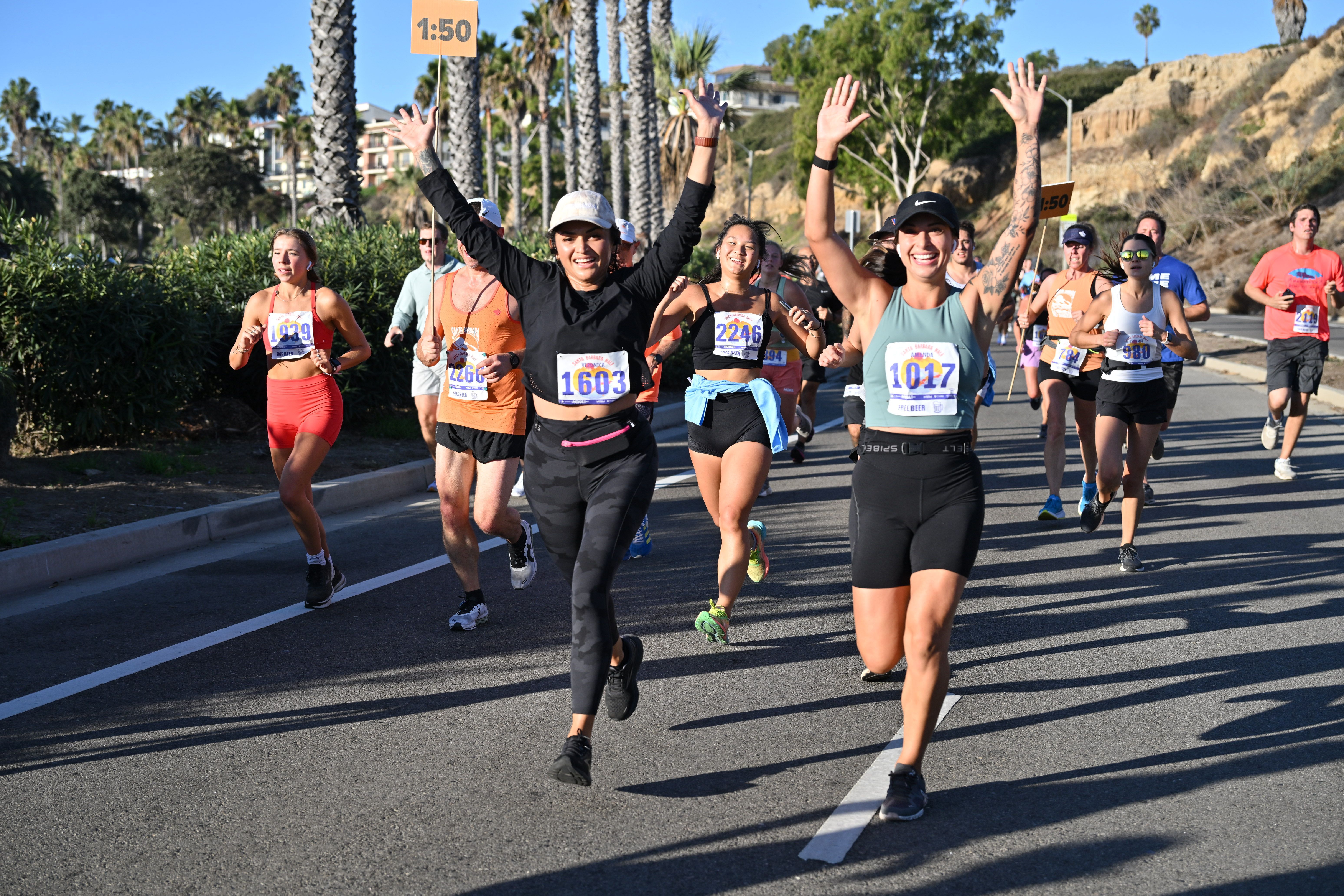 Two women with their hands up at the finish line of the Santa Barbara Half Marathon