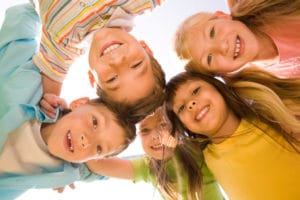 Below view of happy children embracing each other and smiling at camera to show Santa Barbara School District