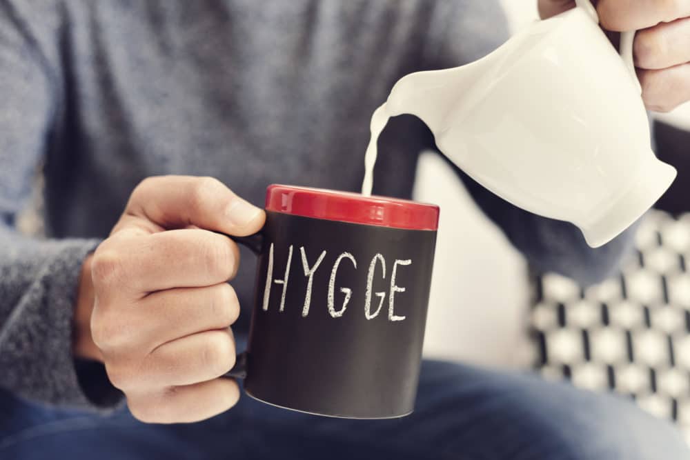 Danish lifestyle trends: man pouring milk into Hygge mug