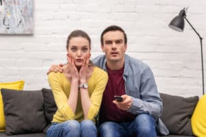 Couple dumbfounded while watching a real estate tv show