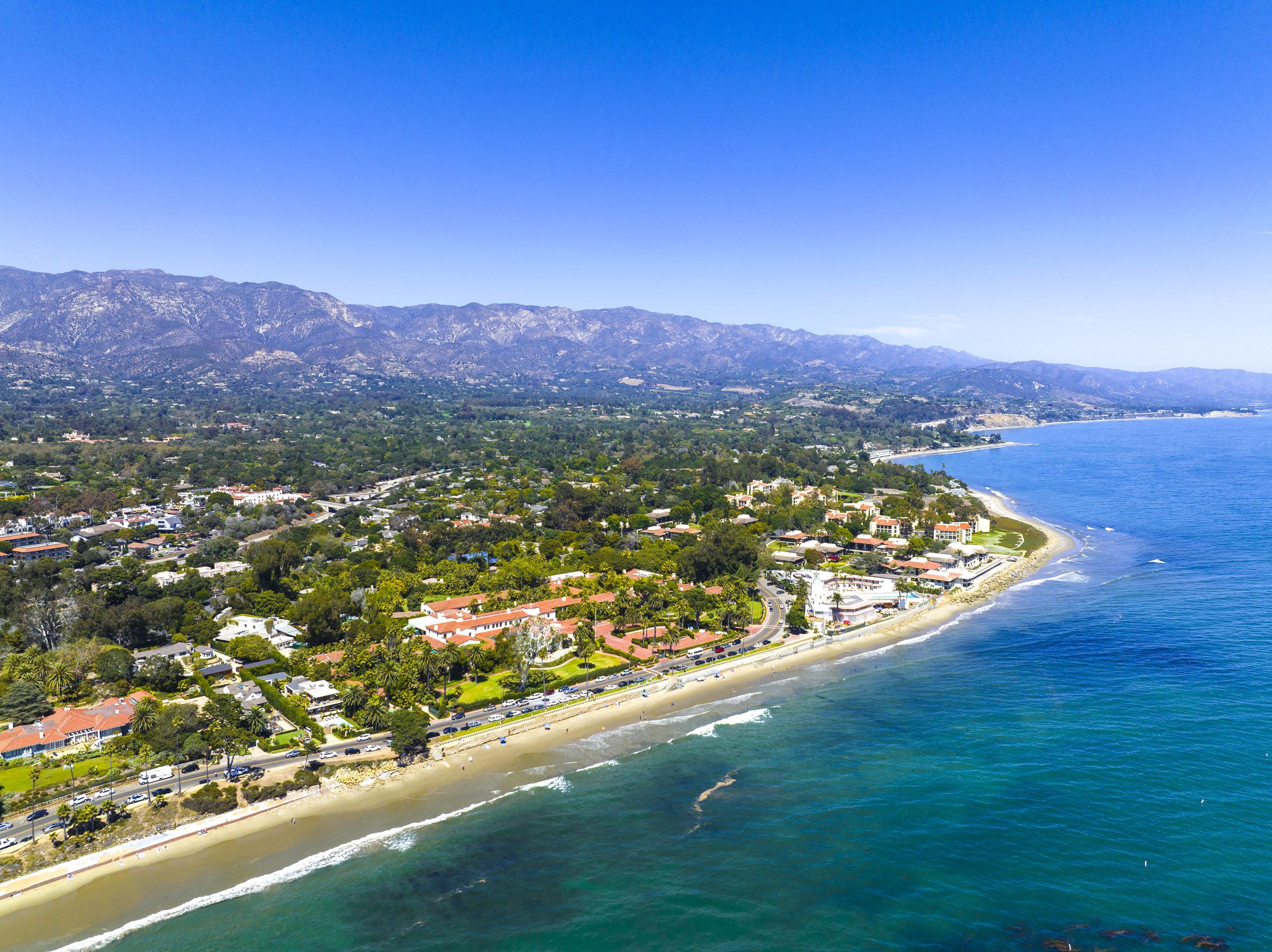 A birds eye view of the coastal town of Montecito with the mountains in the background and the ocean in the foreground