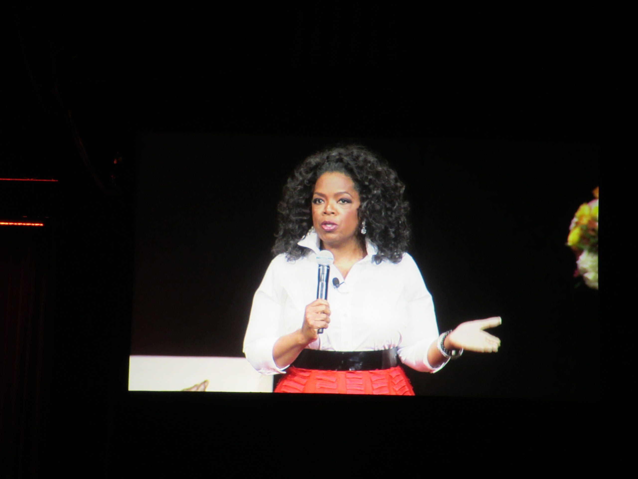 Oprah Winfrey speaking with a microphone in hand.