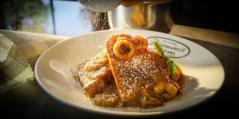 A large plate of delectable-looking French toast, with powdered sugar and fruit