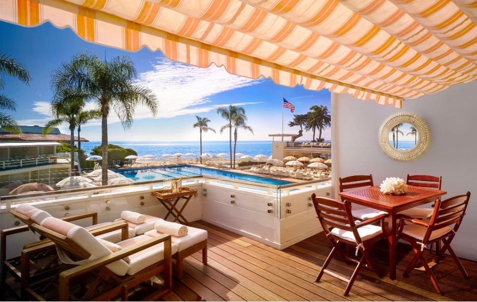 A private cabana above the sparkling pool at the Coral Casino looking out to the ocean with palm trees
