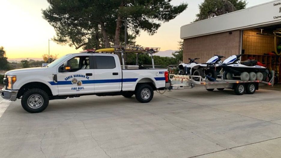 A firefighter vehicle towing two jet skies