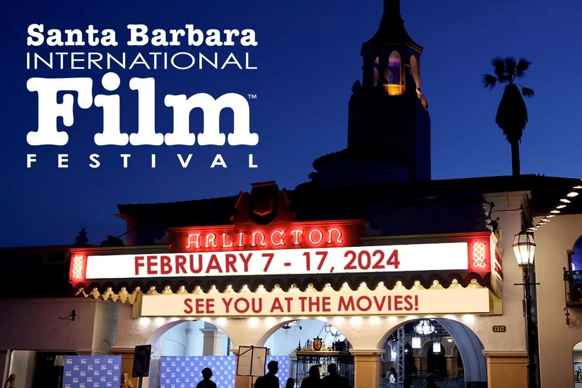 The Arlington Theater and the logo of Santa Barbara International Film Festival under a dark blue sky, with the theater marquee announcing the dates of the Festival.