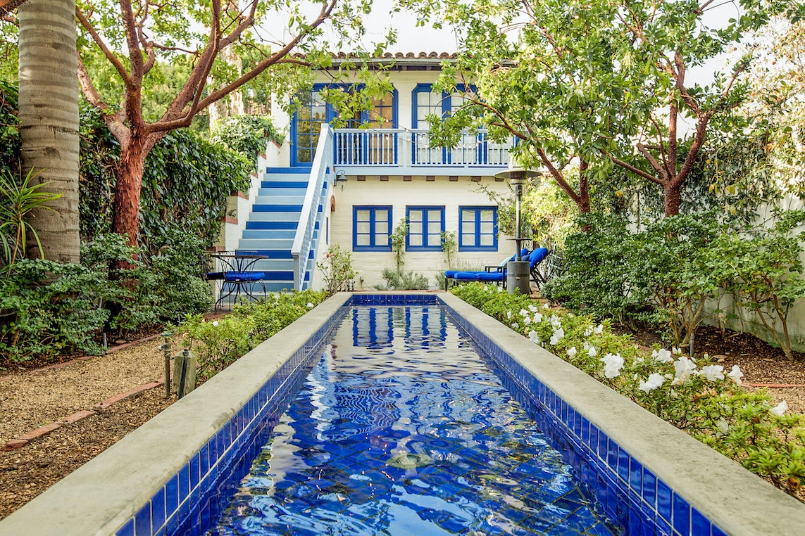 Beautiful blue lap pool in front of blue and cream colored spa.