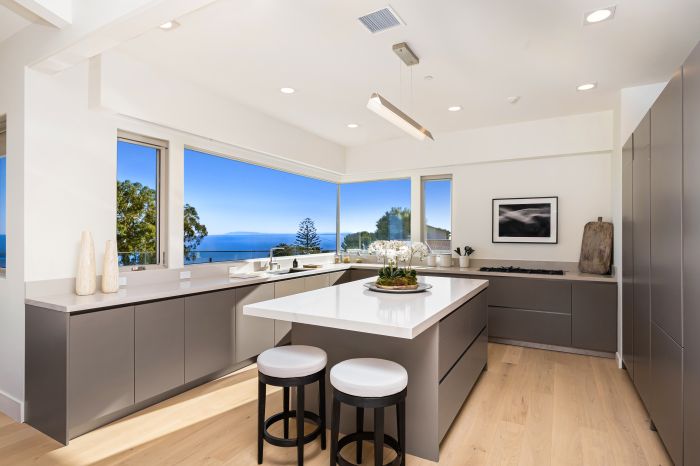 The stylish Italian designer kitchen of a Ventura home, with large windows and an ocean view