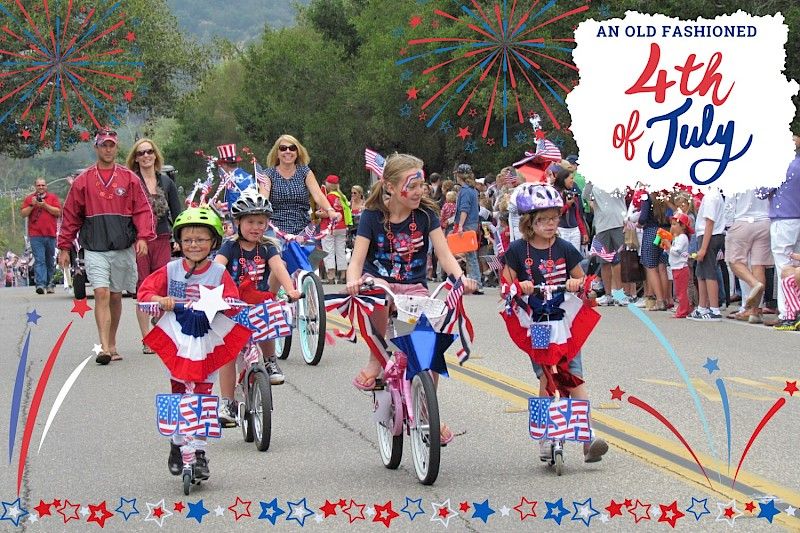 A 4th of July street parade led by young girls on bikes, with parents and more children in the background.