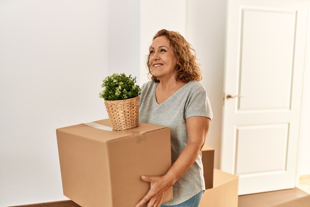 Senior woman moving boxes while downsizing