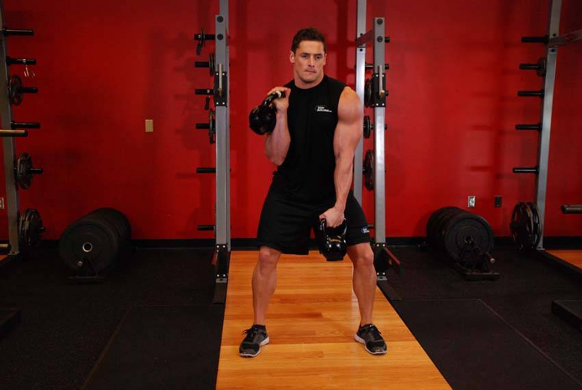 Double Kettlebell Alternating Hang Clean — end position, working the hamstrings