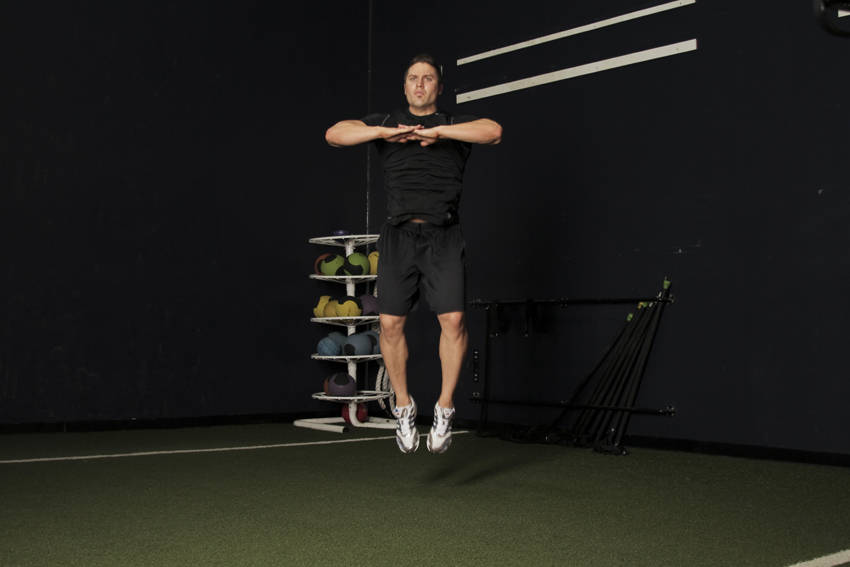 Knee Tuck Jump — end position, working the hamstrings