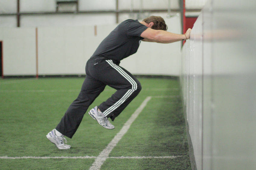 Linear Acceleration Wall Drill — end position, working the hamstrings