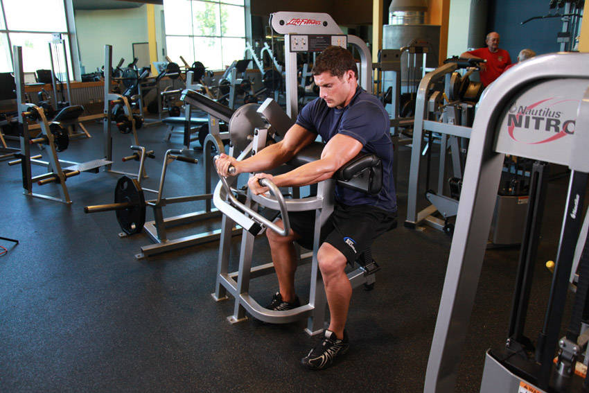 Machine Preacher Curls — starting position, working the biceps