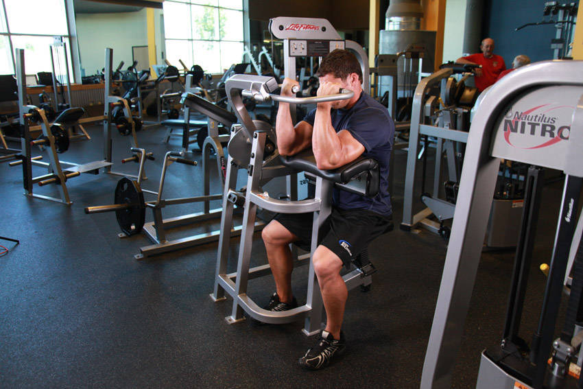 Machine Preacher Curls — end position, working the biceps