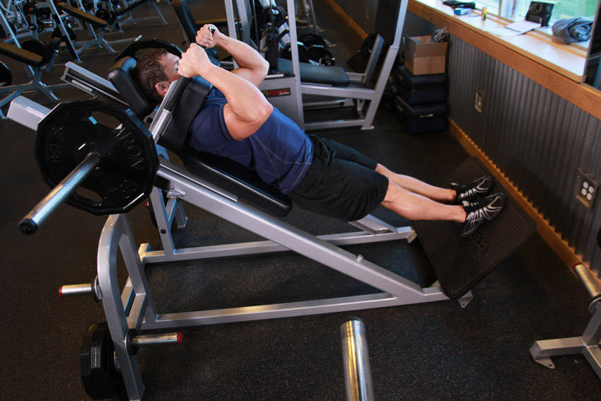 Narrow Stance Hack Squats — end position, working the quads