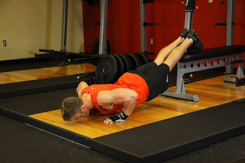 Push-Ups With Feet Elevated — end position, working the chest