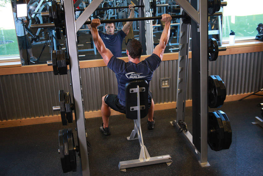 Smith Machine Overhead Shoulder Press — end position, working the shoulders