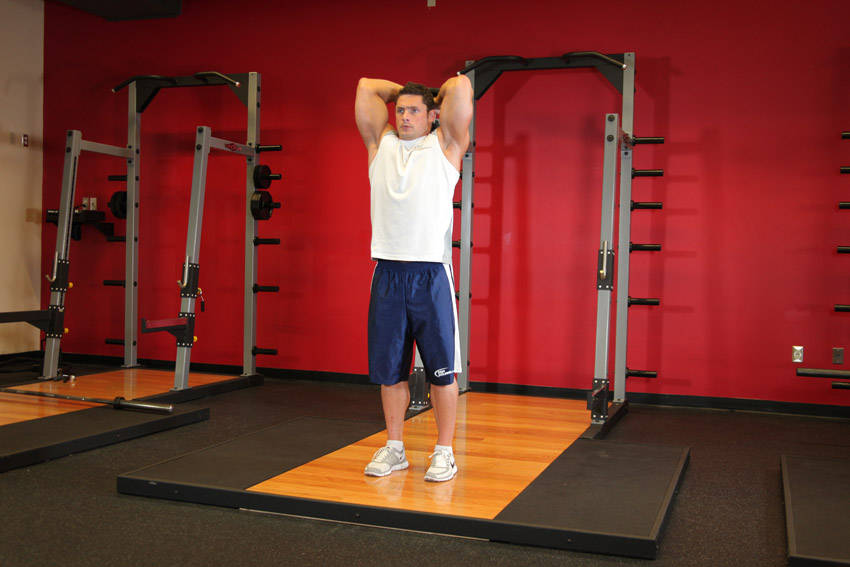 Standing Dumbbell Triceps Extension — end position, working the triceps