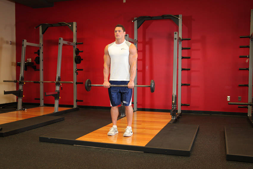 Standing Front Barbell Raise Over Head — starting position, working the shoulders
