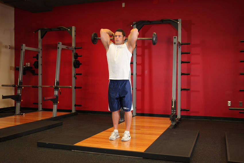 Standing Overhead Barbell Triceps Extension — starting position, working the triceps