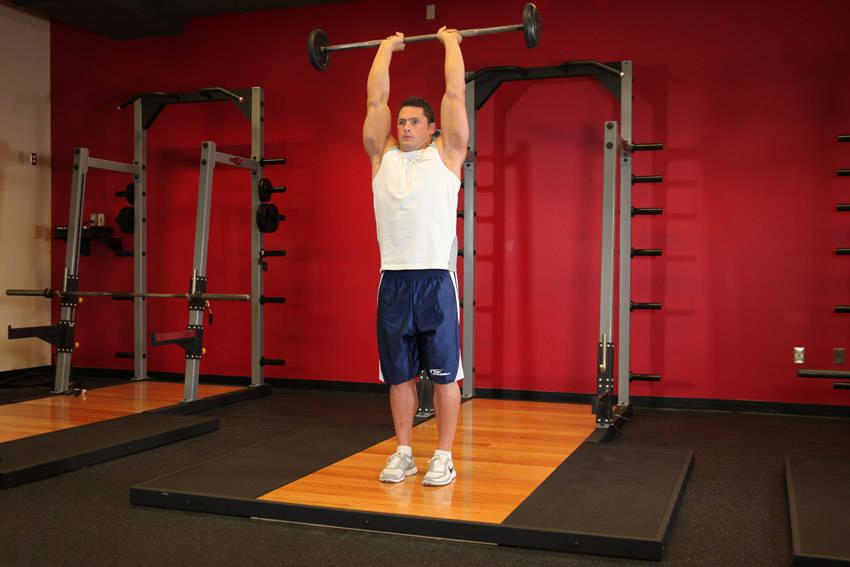 Standing Overhead Barbell Triceps Extension — end position, working the triceps