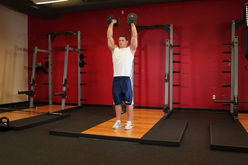 Standing Palms-In Dumbbell Press — starting position, working the shoulders