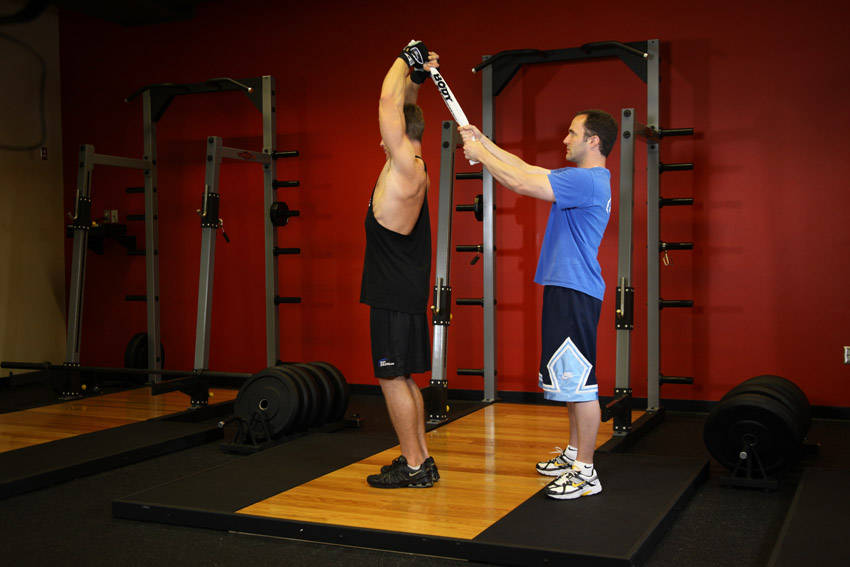 Standing Towel Triceps Extension — end position, working the triceps