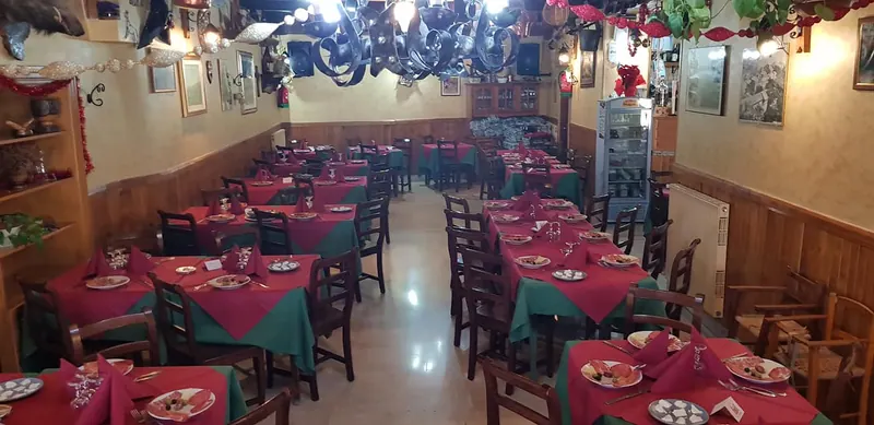 La sala coi tavoli apparecchiati di rosso e verde