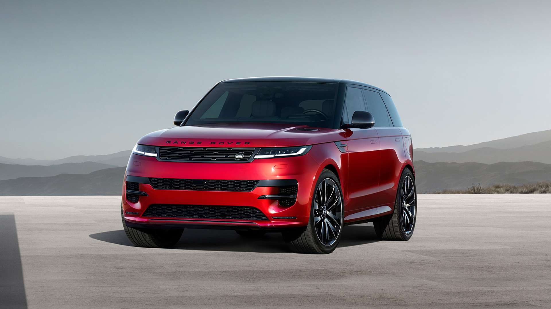 Red Range Rover parked by the water