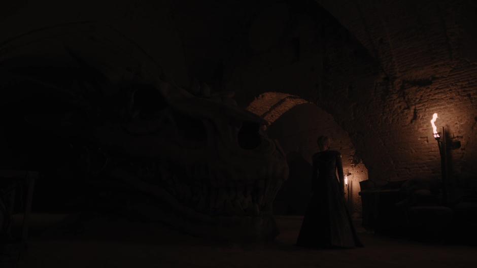 Cersei examines the giant dragon skull.