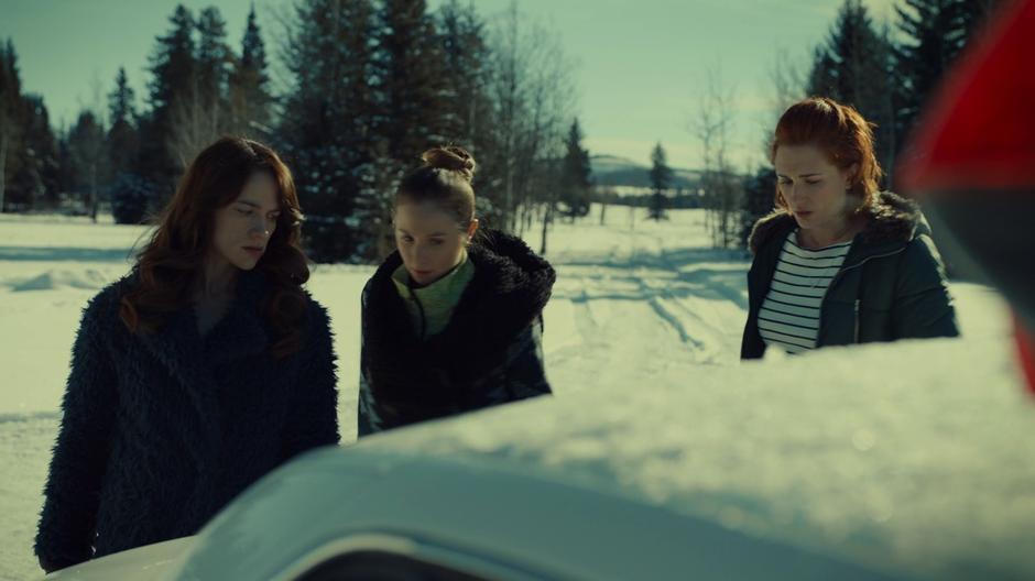 Wynonna and Waverly look down at the trunk containing Jonas while Nicole struggles with her hangover.