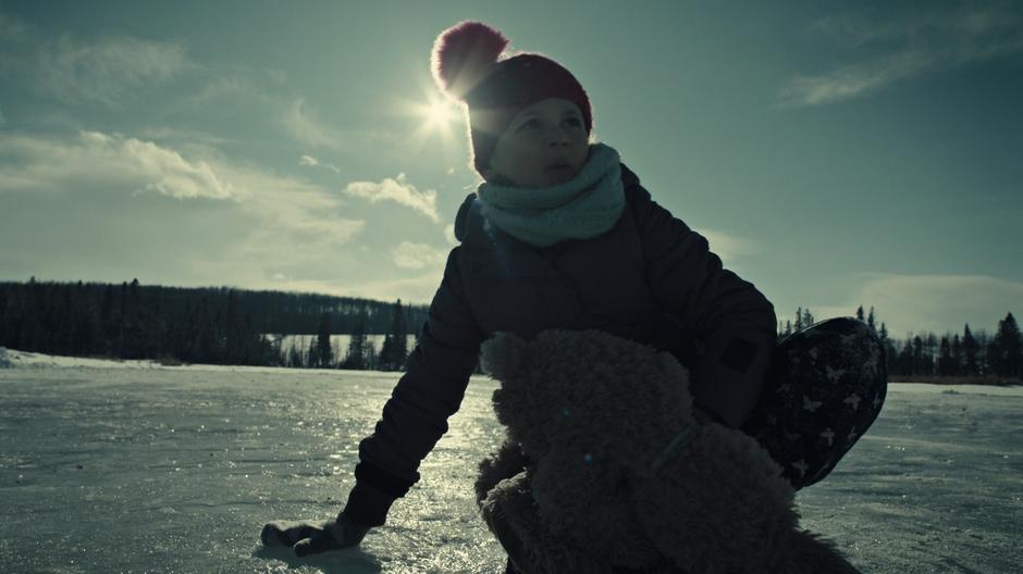 Young Waverly looks back across the frozen lake as the ice starts to crack.